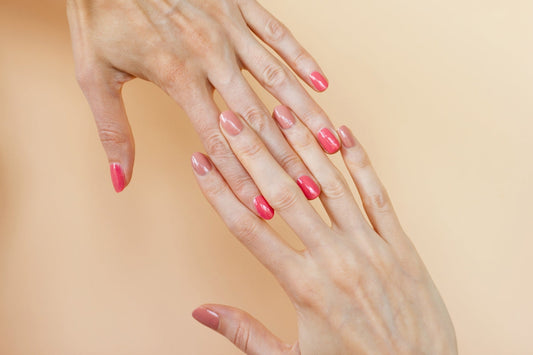 A woman's hands with pink manicures on them